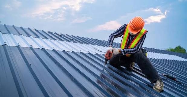 Roofer fixing sheet roofing on a domestic property
